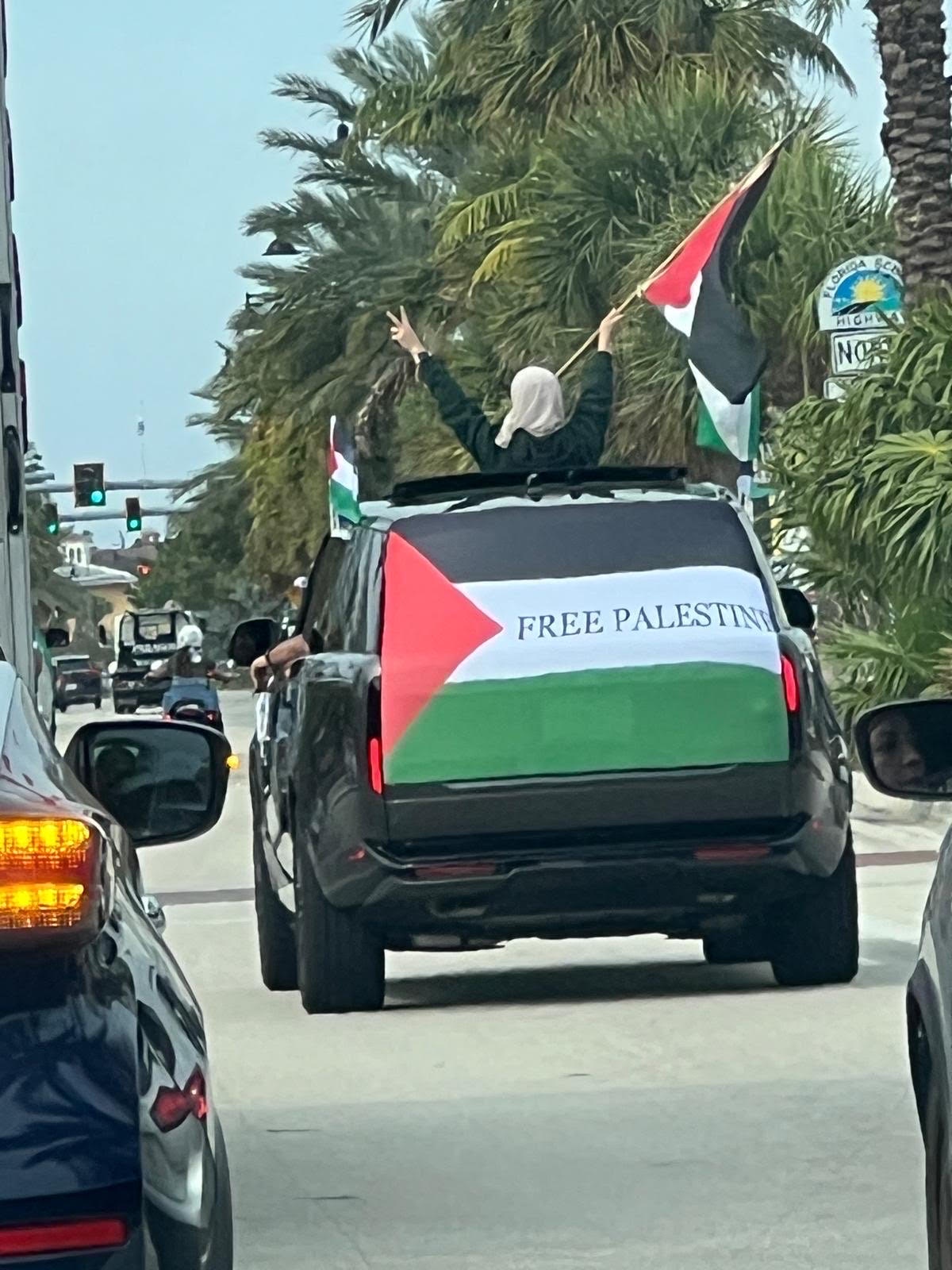 Demonstrators wave the Palestinian flag form a vehicle in South Florida. | Fight Back! News/staff