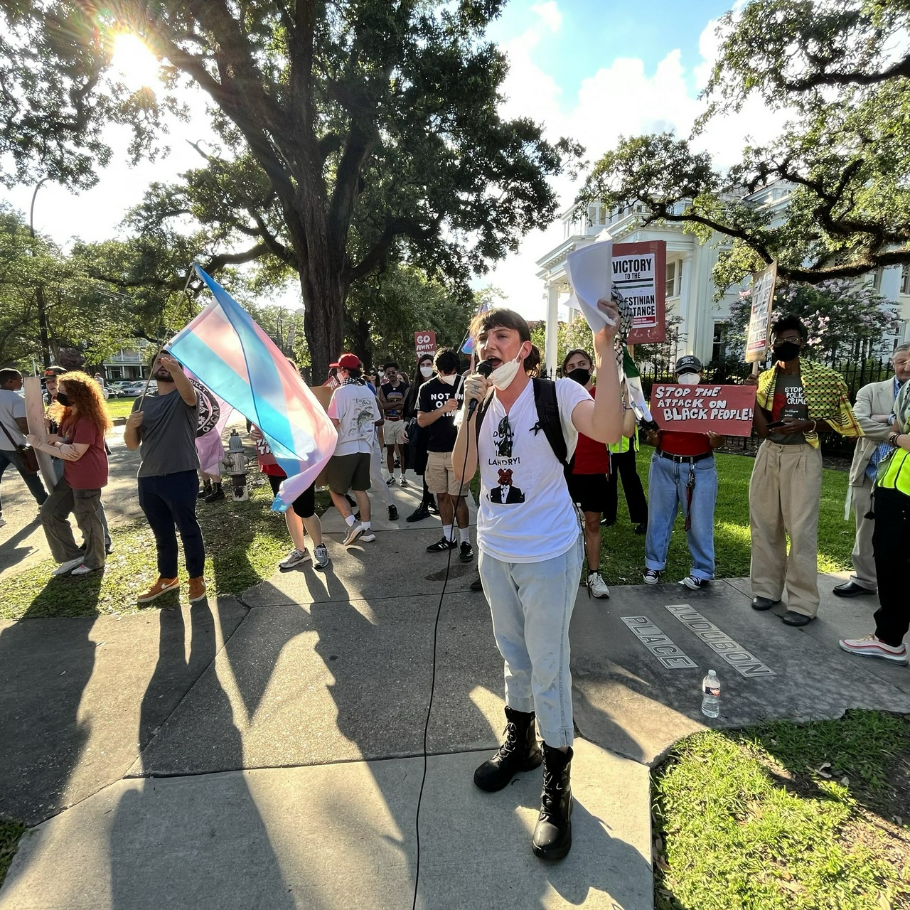 New Orleans protesters stand in front of Audubon Place holding anti-Trump and anti-GOP signs and flags.  | Staff/Fight Back! News