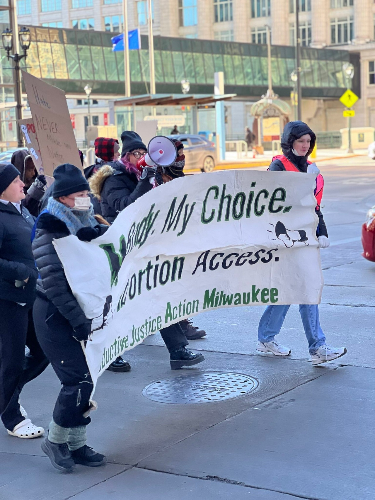 A group of protesters marching holding a banner.