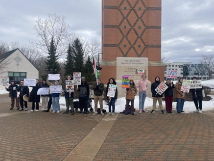 Students hold signs and a Palestinian flag in a campus square.