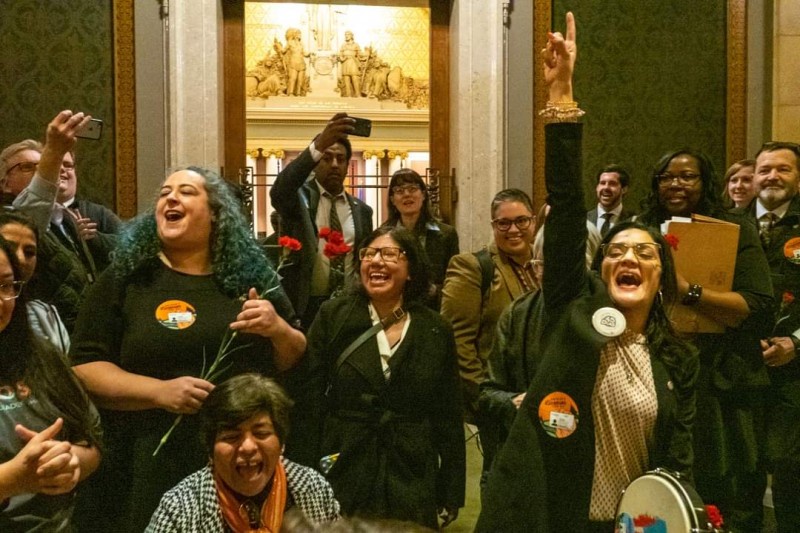 People celebrate after House votes to pass driver's license for all bill.
