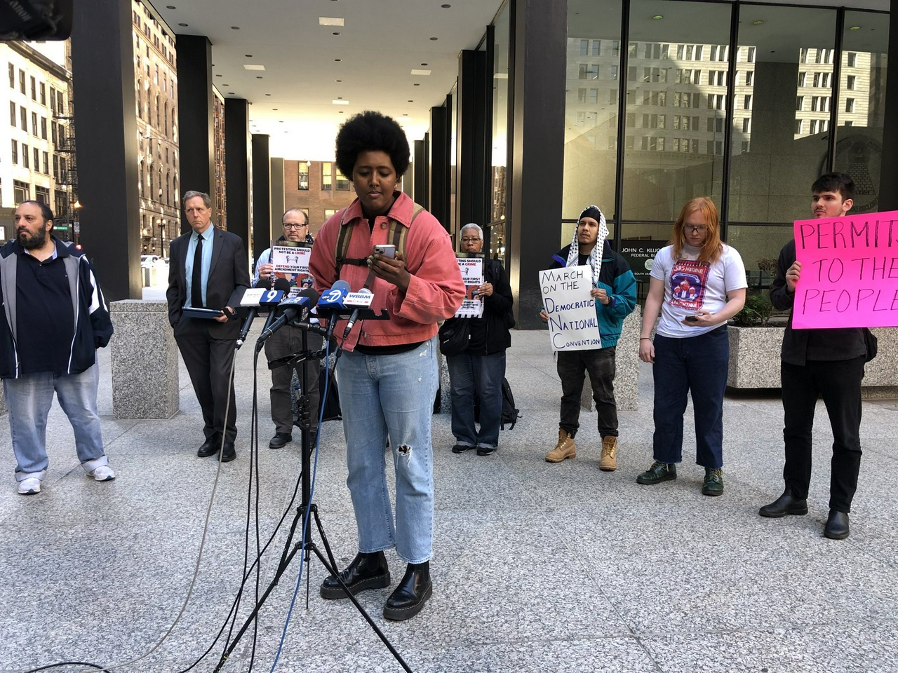 Faayani Aboma Mijana speaks at press conference about a move in federal court for a preliminary injunction to march on the Democratic National Convention.  | Fight Back! News/staff