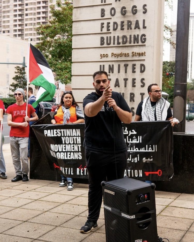 Hakm Murad, an organizer with Palestinian Youth Movement, speaks to protestors in front of the Hale Boggs Federal Building. 