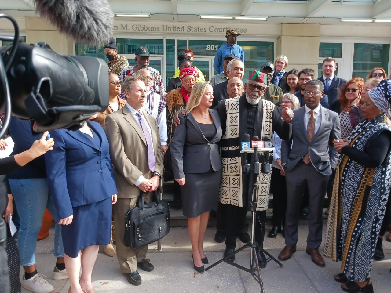 Uhuru 3 and their loved ones and legal representatives gather in front of the courthouse for a press conference.