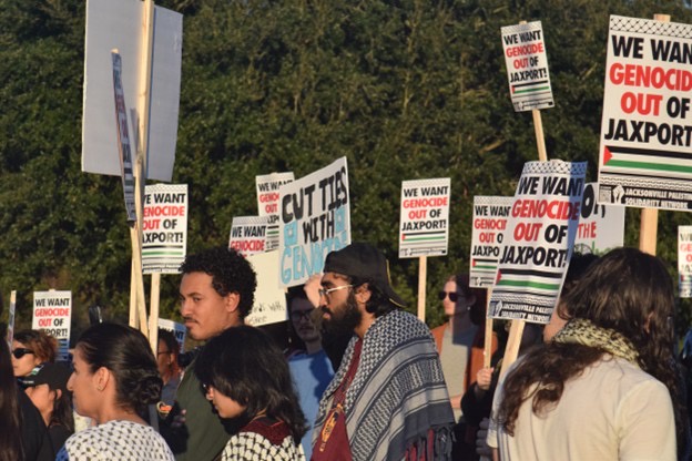 Protesters gather with signs reading “We want genocide out of JAXPORT.”