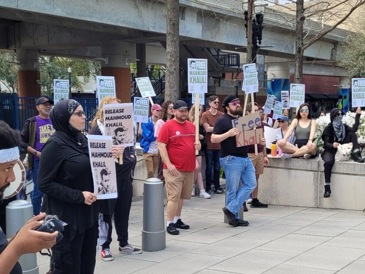 A group of people stands holding signs reading, "Release Mahmoud Khalil."