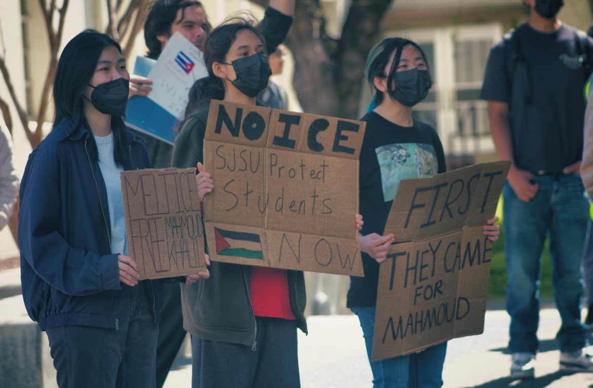 A group of people standing holding signs.