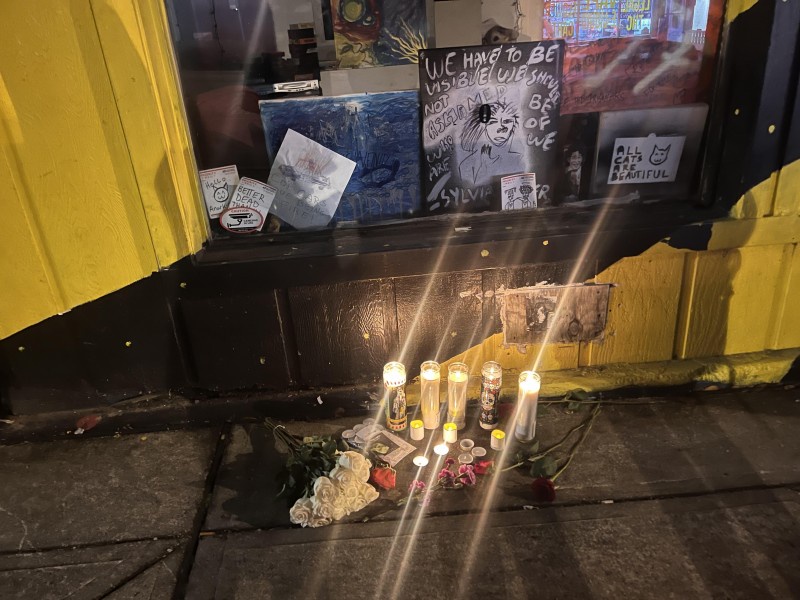 Mourners laid flowers and lit candles for Manny Paez in front of their art.