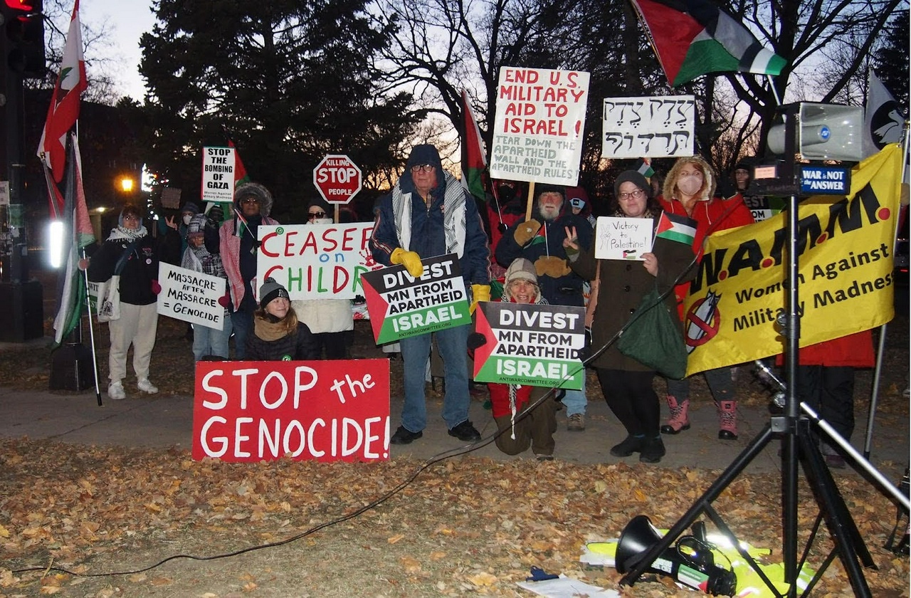 A Palestine protest with people holding signs and banners.