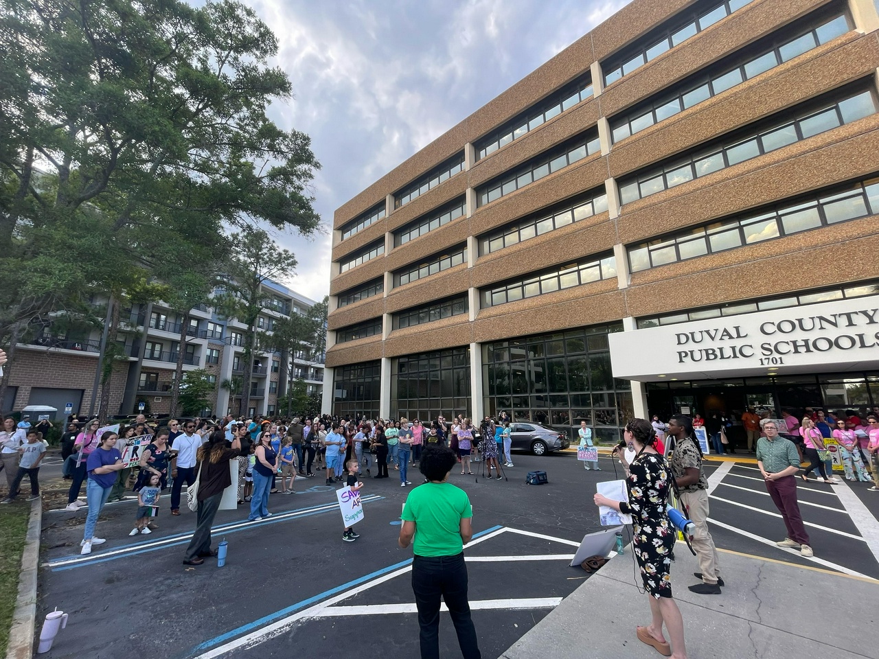 Activist holding microphone rallies against mass layoffs and school closures