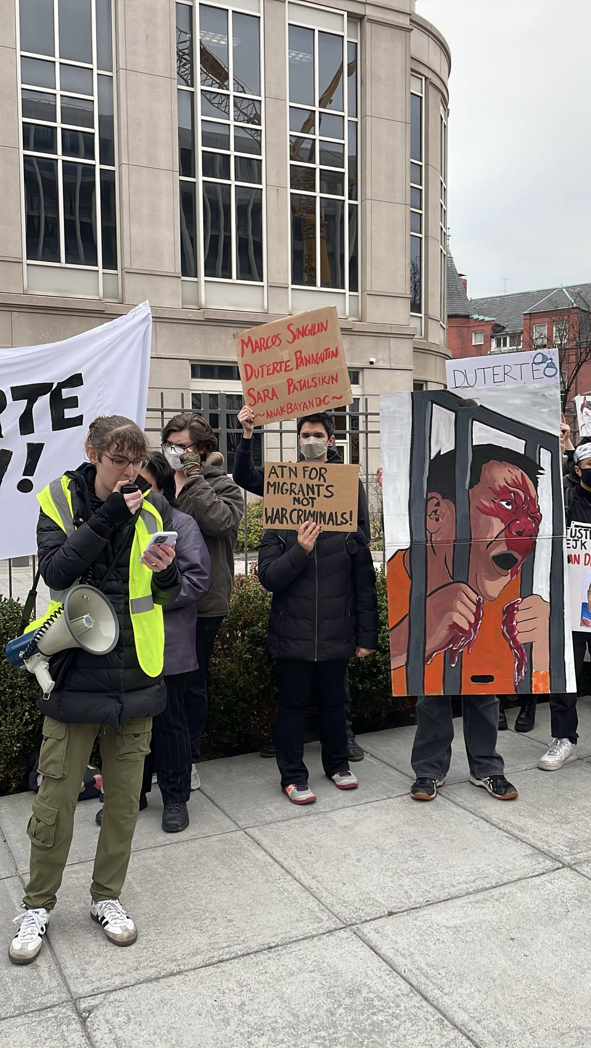 A group of protesters are gathered with signs denouncing former ex-dictator of the Philippines, Duterte