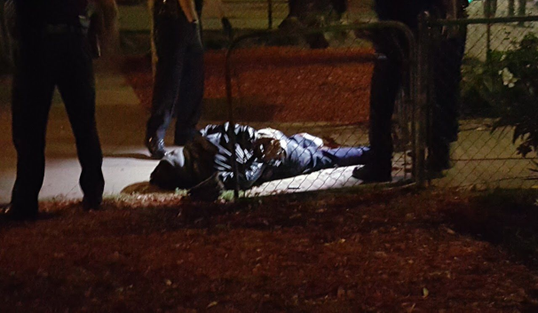 Nearly dead, Alfredo Santibañez on the ground, surrounded by cops.